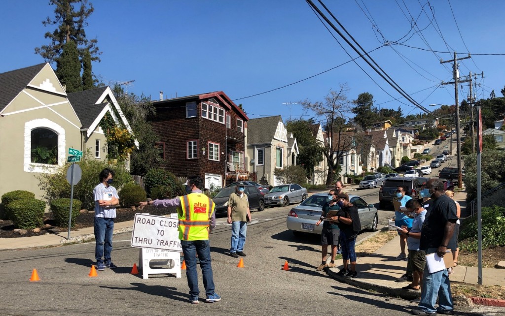 Oakland road closure sign — Road Closed to Thru Traffic with traffic cones and observers